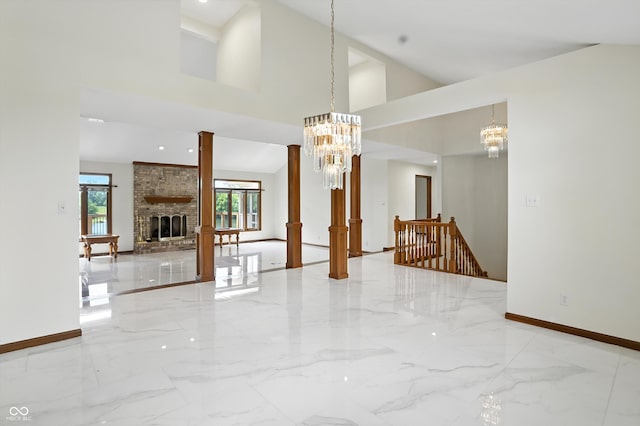1326 Pebble Brook Dr, Noblesville, IN 46062 - unfurnished living room featuring a chandelier, marble tiled flooring, a fireplace, and a towering ceiling