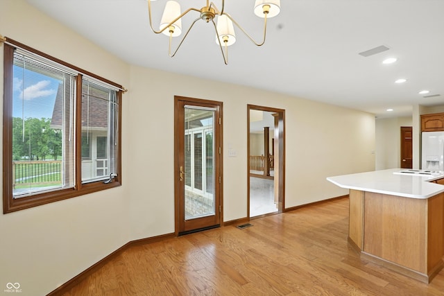1326 Pebble Brook Dr, Noblesville, IN 46062 - kitchen with a chandelier, light countertops, light wood-style floors, recessed lighting, and white refrigerator with ice dispenser