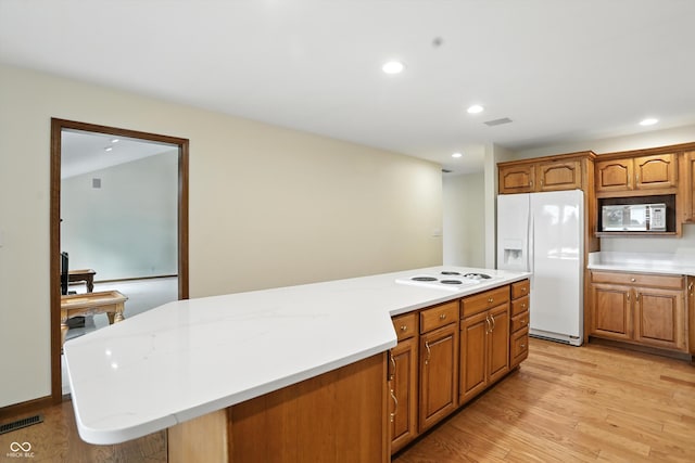1326 Pebble Brook Dr, Noblesville, IN 46062 - kitchen with white appliances, light countertops, light wood-style flooring, a kitchen island, and brown cabinets