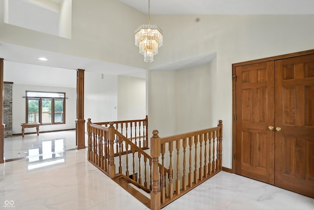 1326 Pebble Brook Dr, Noblesville, IN 46062 - entryway with high vaulted ceiling, light marble finish flooring, a chandelier, and decorative columns