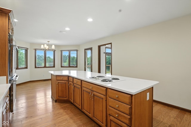1326 Pebble Brook Dr, Noblesville, IN 46062 - kitchen featuring white electric stovetop, a chandelier, light countertops, light wood finished floors, and recessed lighting