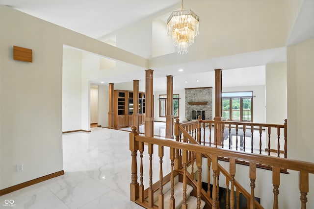 1326 Pebble Brook Dr, Noblesville, IN 46062 - corridor with an upstairs landing, marble tiled floors, decorative columns, a chandelier, and high vaulted ceiling