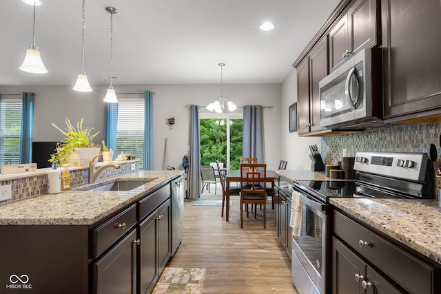 2421 Creek Bank Dr, Columbus, IN 47201 - kitchen featuring appliances with stainless steel finishes, a chandelier, decorative backsplash, light wood-style flooring, and dark brown cabinetry