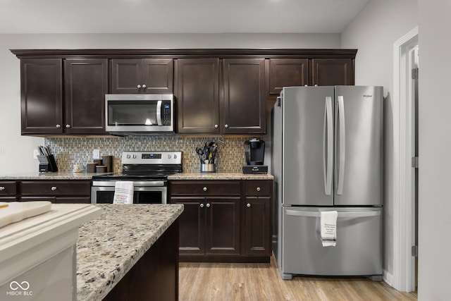2421 Creek Bank Dr, Columbus, IN 47201 - kitchen with stainless steel appliances, dark brown cabinets, backsplash, and light wood-style flooring