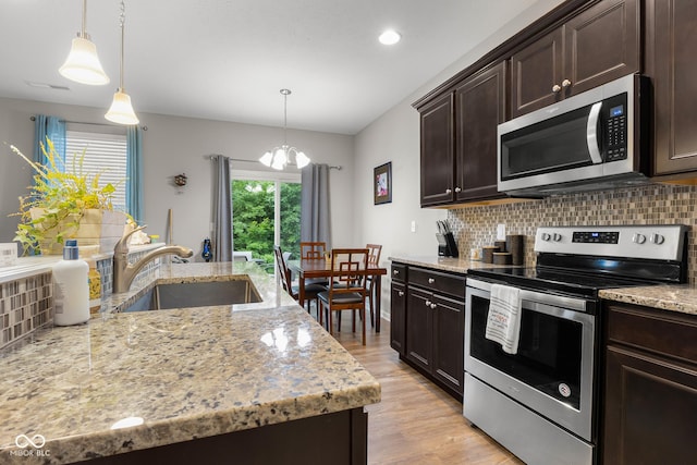 2421 Creek Bank Dr, Columbus, IN 47201 - kitchen featuring appliances with stainless steel finishes, a chandelier, decorative backsplash, dark brown cabinets, and decorative light fixtures
