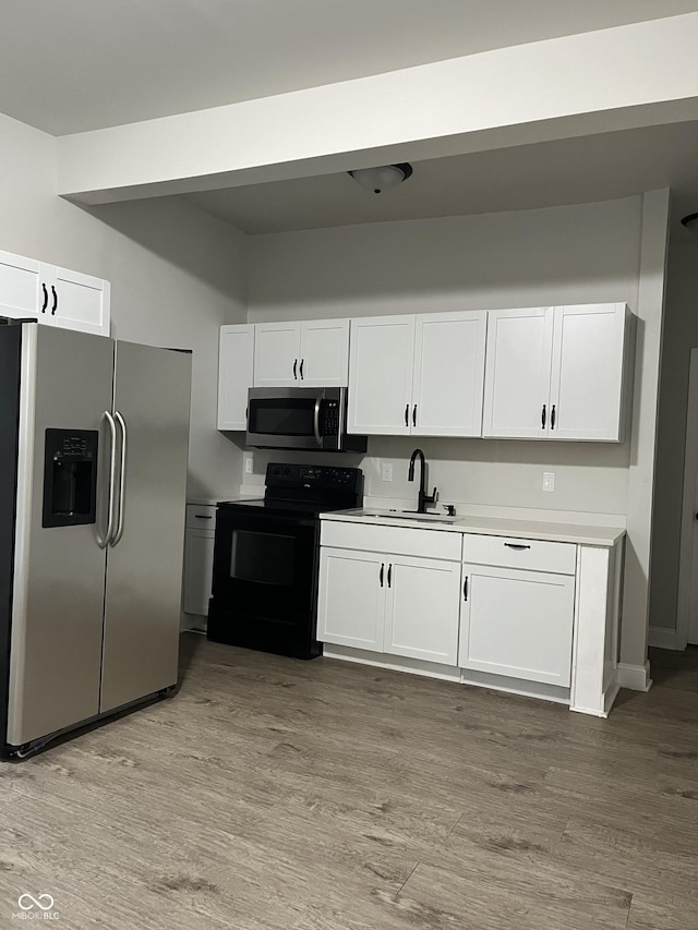 319 HST W 10th St, Anderson, IN 46016 - kitchen featuring appliances with stainless steel finishes, white cabinets, and light wood-style floors