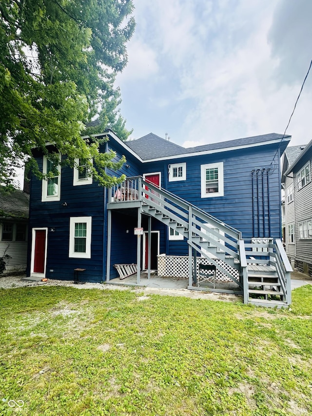 319 HST W 10th St, Anderson, IN 46016 - rear view of house with stairway, a wooden deck, and a lawn