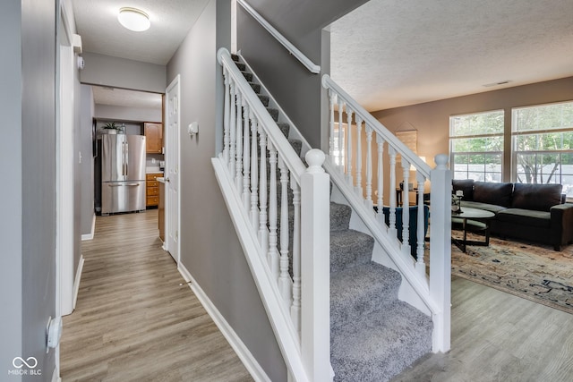 2289 Salem Park Dr, Indianapolis, IN 46239 - staircase with a textured ceiling and wood finished floors