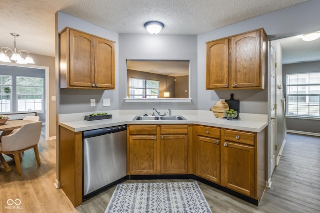 2289 Salem Park Dr, Indianapolis, IN 46239 - kitchen featuring stainless steel dishwasher, light countertops, light wood finished floors, brown cabinets, and a textured ceiling