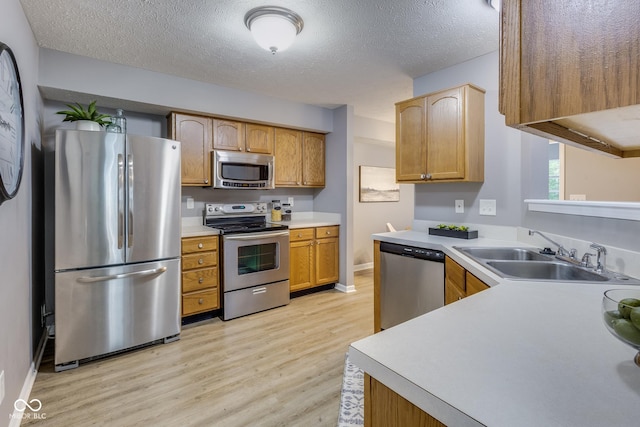 2289 Salem Park Dr, Indianapolis, IN 46239 - kitchen featuring appliances with stainless steel finishes, light wood-type flooring, light countertops, and a textured ceiling