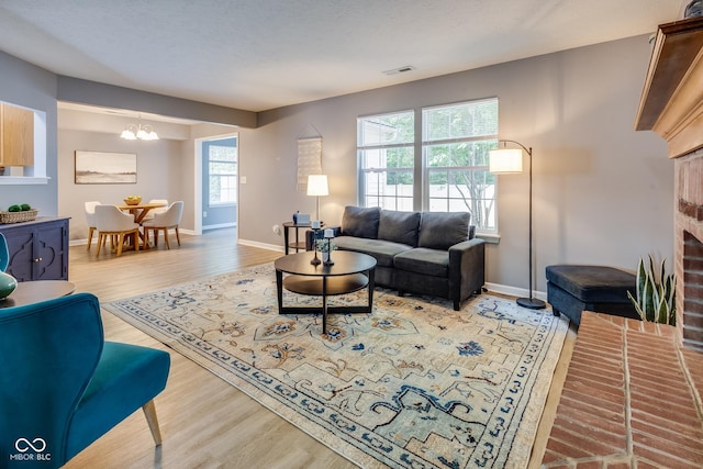 2289 Salem Park Dr, Indianapolis, IN 46239 - living room featuring a fireplace, wood finished floors, and a chandelier