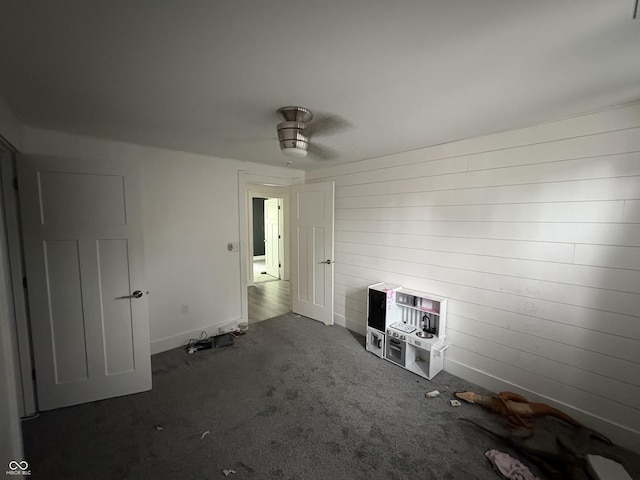 917 N Rural St, Indianapolis, IN 46201 - empty room featuring carpet, wooden walls, and a ceiling fan