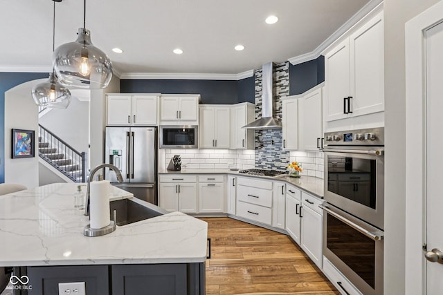 2105 Granville Dr, Westfield, IN 46074 - kitchen featuring appliances with stainless steel finishes, wall chimney exhaust hood, ornamental molding, light wood-type flooring, and recessed lighting