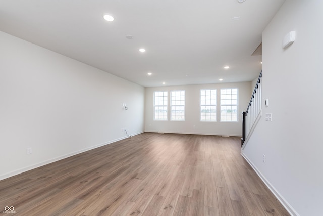 14521 Hanford Ln, Carmel, IN 46074 - unfurnished living room featuring recessed lighting, wood finished floors, and stairway