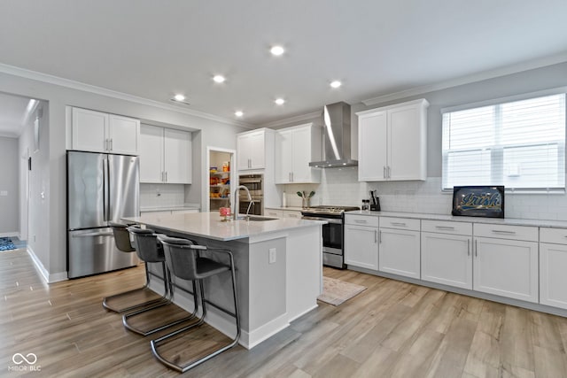15546 Senita Ln, Fishers, IN 46037 - kitchen featuring stainless steel appliances, wall chimney exhaust hood, ornamental molding, a kitchen island with sink, and white cabinetry