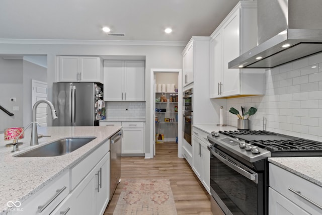 15546 Senita Ln, Fishers, IN 46037 - kitchen with appliances with stainless steel finishes, wall chimney exhaust hood, tasteful backsplash, white cabinetry, and ornamental molding