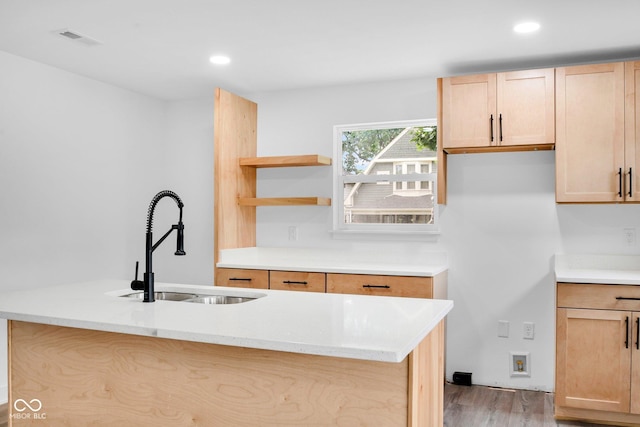 1555 N Dearborn St, Indianapolis, IN 46201 - kitchen with light wood-style floors, an island with sink, recessed lighting, light brown cabinets, and open shelves