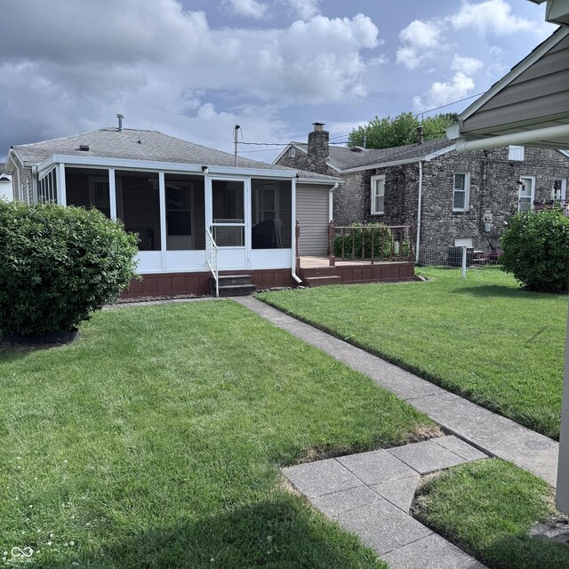 206 W 2nd St, Greensburg, IN 47240 - back of property featuring a sunroom, a lawn, and roof with shingles