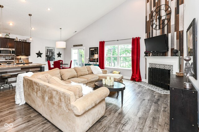 561 Farnham Dr, Westfield, IN 46074 - living room featuring wood finished floors, a tile fireplace, high vaulted ceiling, and recessed lighting