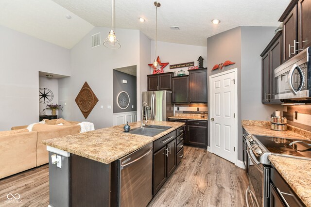 561 Farnham Dr, Westfield, IN 46074 - kitchen with appliances with stainless steel finishes, high vaulted ceiling, light wood-style flooring, and dark brown cabinets