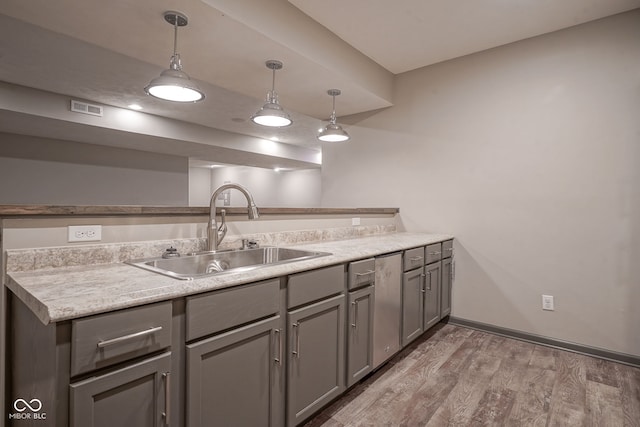 6471 W Clearview Dr, Mccordsville, IN 46055 - kitchen with gray cabinetry, light wood-style flooring, decorative light fixtures, and light countertops