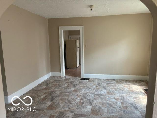 822 W 7th St, Muncie, IN 47302 - spare room featuring arched walkways, stone finish floors, and a textured ceiling