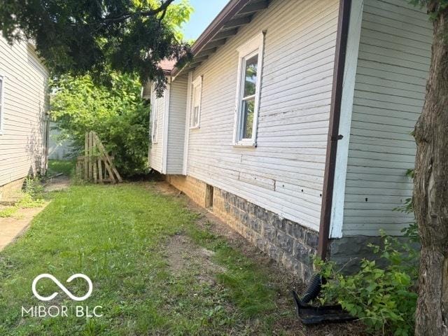 822 W 7th St, Muncie, IN 47302 - view of property exterior featuring crawl space and a yard