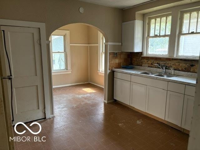 822 W 7th St, Muncie, IN 47302 - kitchen featuring healthy amount of natural light, white cabinets, arched walkways, and light countertops