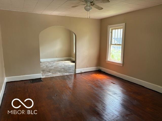 822 W 7th St, Muncie, IN 47302 - empty room with arched walkways, ceiling fan, and wood finished floors