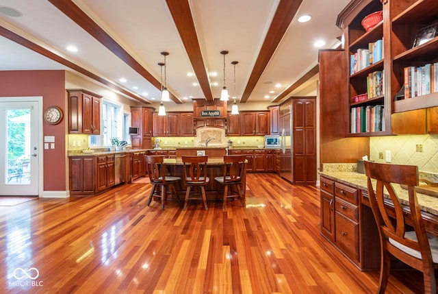 3104 E Chase Ln E, Bloomington, IN 47401 - kitchen featuring appliances with stainless steel finishes, backsplash, a breakfast bar area, wood finished floors, and beamed ceiling