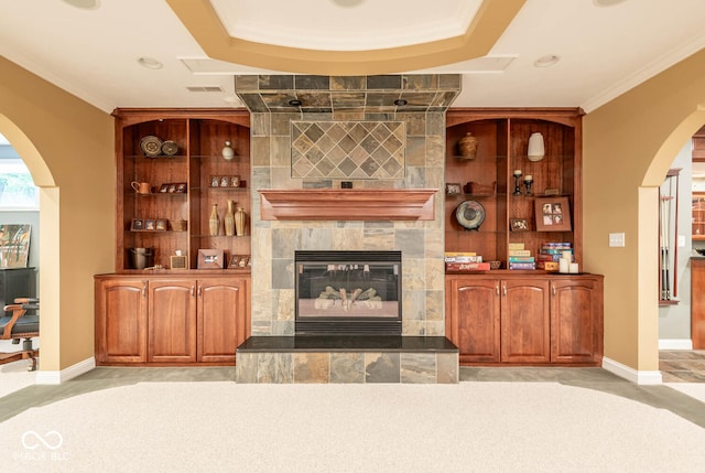 3104 E Chase Ln E, Bloomington, IN 47401 - living area with arched walkways, light carpet, a tiled fireplace, and crown molding