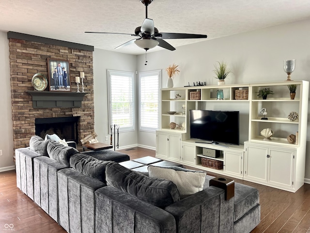 13895 Cloverfield Cir, Fishers, IN 46038 - living area with dark wood-style flooring, ceiling fan, a stone fireplace, and a textured ceiling