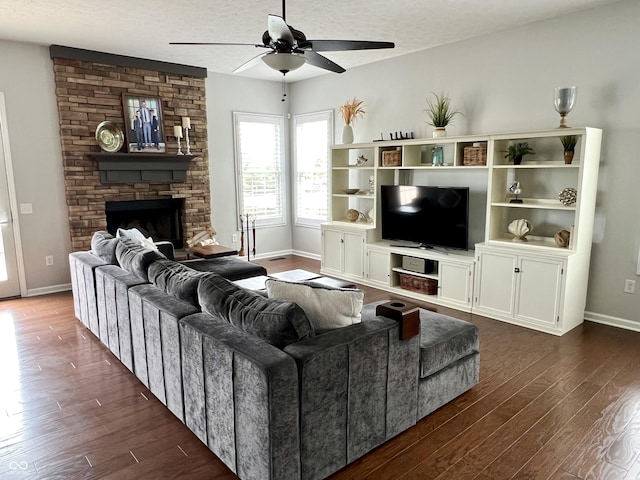 13895 Cloverfield Cir, Fishers, IN 46038 - living room featuring dark wood-type flooring, a stone fireplace, ceiling fan, and a textured ceiling