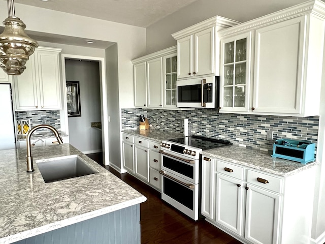 13895 Cloverfield Cir, Fishers, IN 46038 - kitchen featuring stainless steel microwave, range with two ovens, tasteful backsplash, dark wood finished floors, and glass insert cabinets