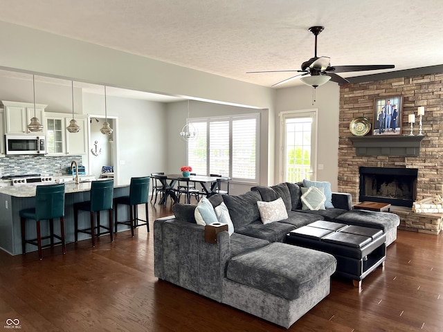 13895 Cloverfield Cir, Fishers, IN 46038 - living room with ceiling fan, dark wood-type flooring, a fireplace, and a textured ceiling