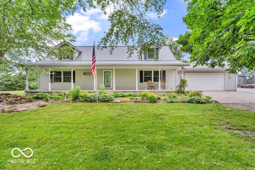 3139 E 150 S, Crawfordsville, IN 47933 - view of front of home featuring a porch, a garage, a front lawn, and driveway