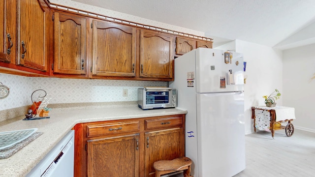 1067 Acadia Ct, Indianapolis, IN 46217 - kitchen featuring white appliances, backsplash, brown cabinets, light countertops, and light wood-style flooring