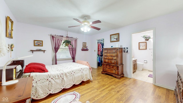1067 Acadia Ct, Indianapolis, IN 46217 - bedroom featuring a spacious closet, light wood-type flooring, ensuite bathroom, a ceiling fan, and a closet