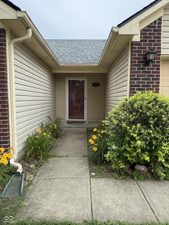 8113 Maple Stream Ln, Indianapolis, IN 46217 - view of exterior entry with a shingled roof and brick siding