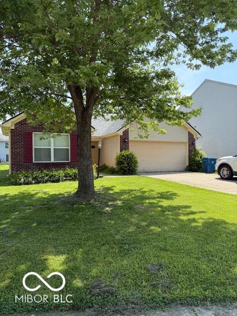 8113 Maple Stream Ln, Indianapolis, IN 46217 - view of property hidden behind natural elements featuring brick siding, a front lawn, a garage, and driveway