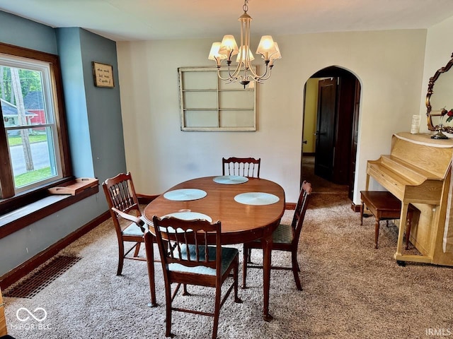 313 S Brittain Ave, Muncie, IN 47303 - carpeted dining area featuring arched walkways, a chandelier, and plenty of natural light