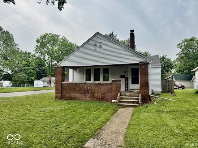 313 S Brittain Ave, Muncie, IN 47303 - bungalow with a front lawn, a chimney, and brick siding