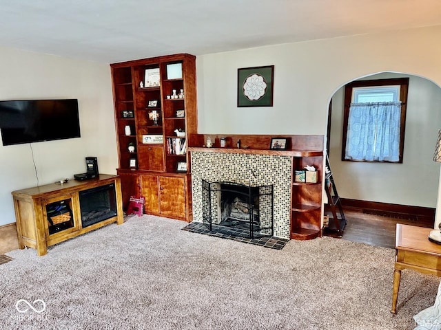 313 S Brittain Ave, Muncie, IN 47303 - carpeted living area with arched walkways and a tile fireplace