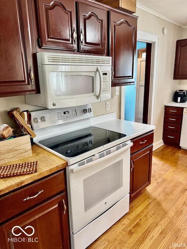 313 S Brittain Ave, Muncie, IN 47303 - kitchen featuring white appliances, ornamental molding, light countertops, light wood-style floors, and dark brown cabinets