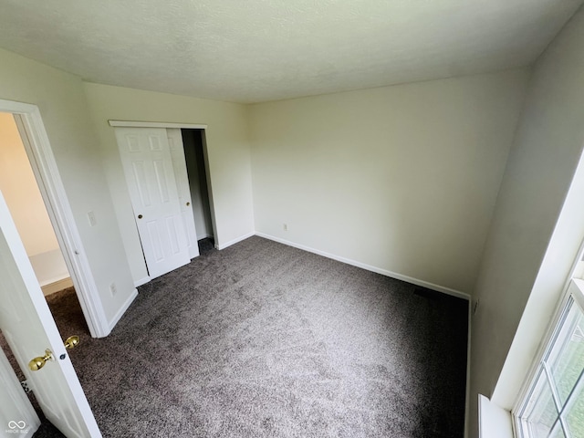 5938 Tybalt Ln, Indianapolis, IN 46254 - unfurnished bedroom featuring dark carpet and a closet