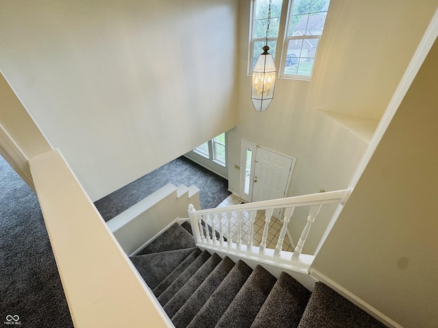 5938 Tybalt Ln, Indianapolis, IN 46254 - stairs featuring carpet flooring, a chandelier, and a high ceiling