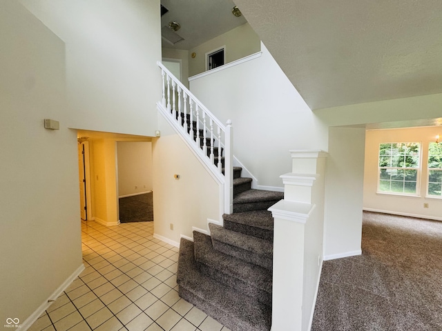5938 Tybalt Ln, Indianapolis, IN 46254 - stairs with a high ceiling, carpet floors, and tile patterned flooring