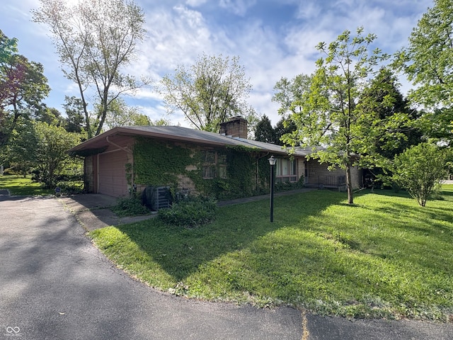 4609 Andover Rd, Indianapolis, IN 46226 - view of property exterior featuring a yard, a chimney, a garage, and driveway
