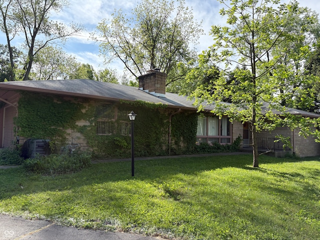 4609 Andover Rd, Indianapolis, IN 46226 - view of side of property with a lawn, stone siding, and a chimney