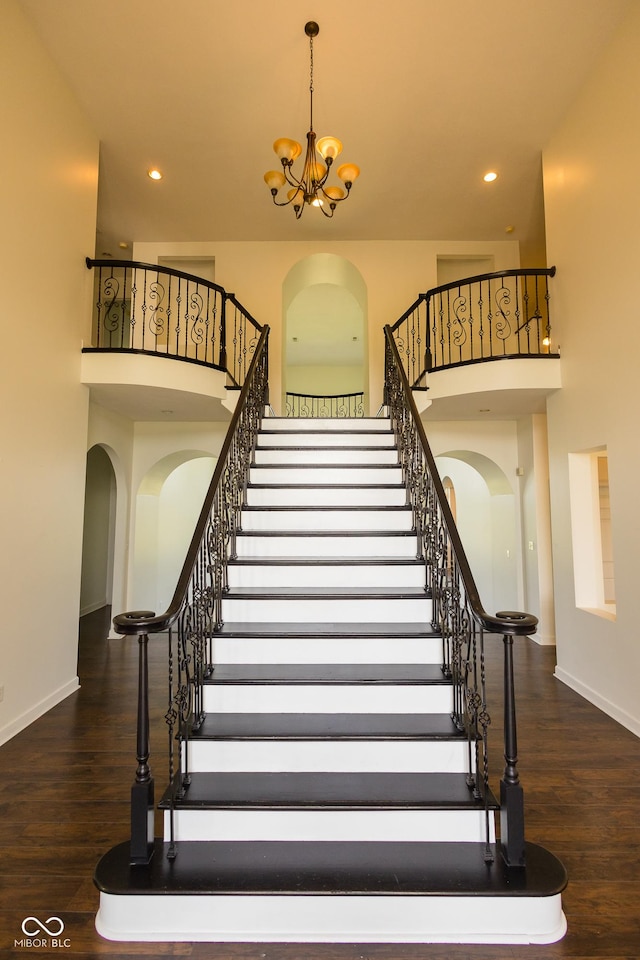 7493 W Lane Rd, Mccordsville, IN 46055 - staircase with arched walkways, a chandelier, a towering ceiling, wood finished floors, and recessed lighting